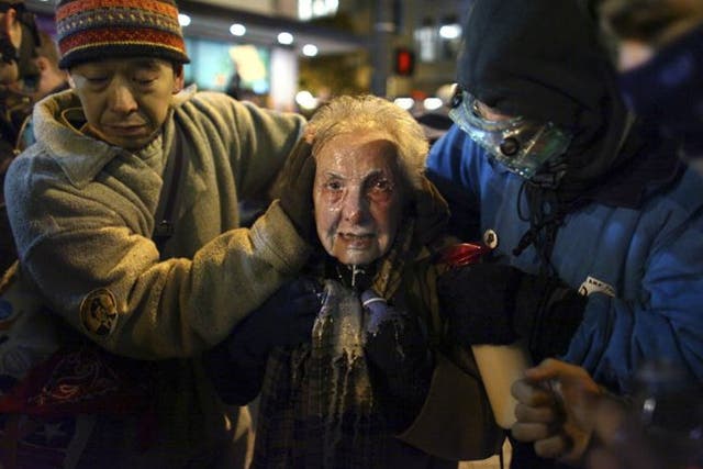 Seattle activist Dorli Rainey, 84, reacts after being hit with pepper spray during an Occupy Seattle protest 