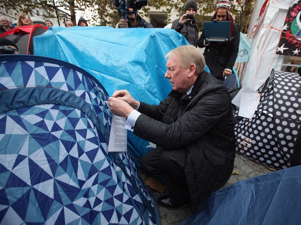 An eviction notice is attached to a tent by a City of London Corporation employee outside St Paul's Cathedral