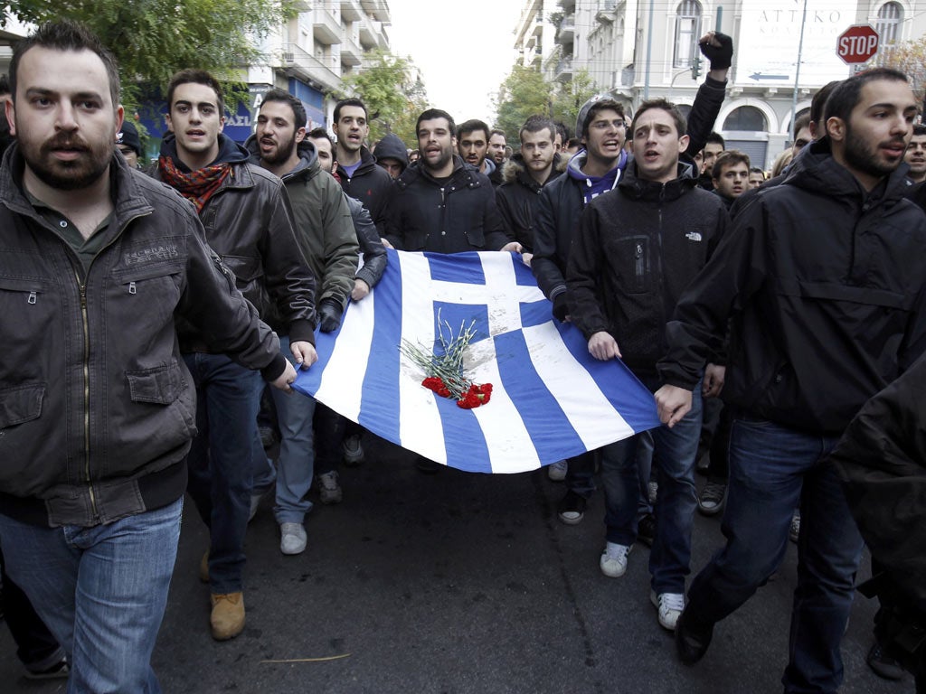 Students carry a blood-stained Greek flag during a rally in Athens marking the anniversary of a 1973 students uprising against the dictatorship then ruling Greece