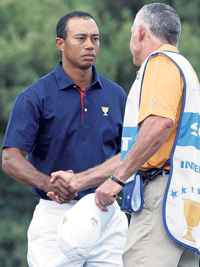 Tiger Woods shakes hands with his former caddie Steve Williams at Royal Melbourne yesterday. Williams racially abused Woods last week