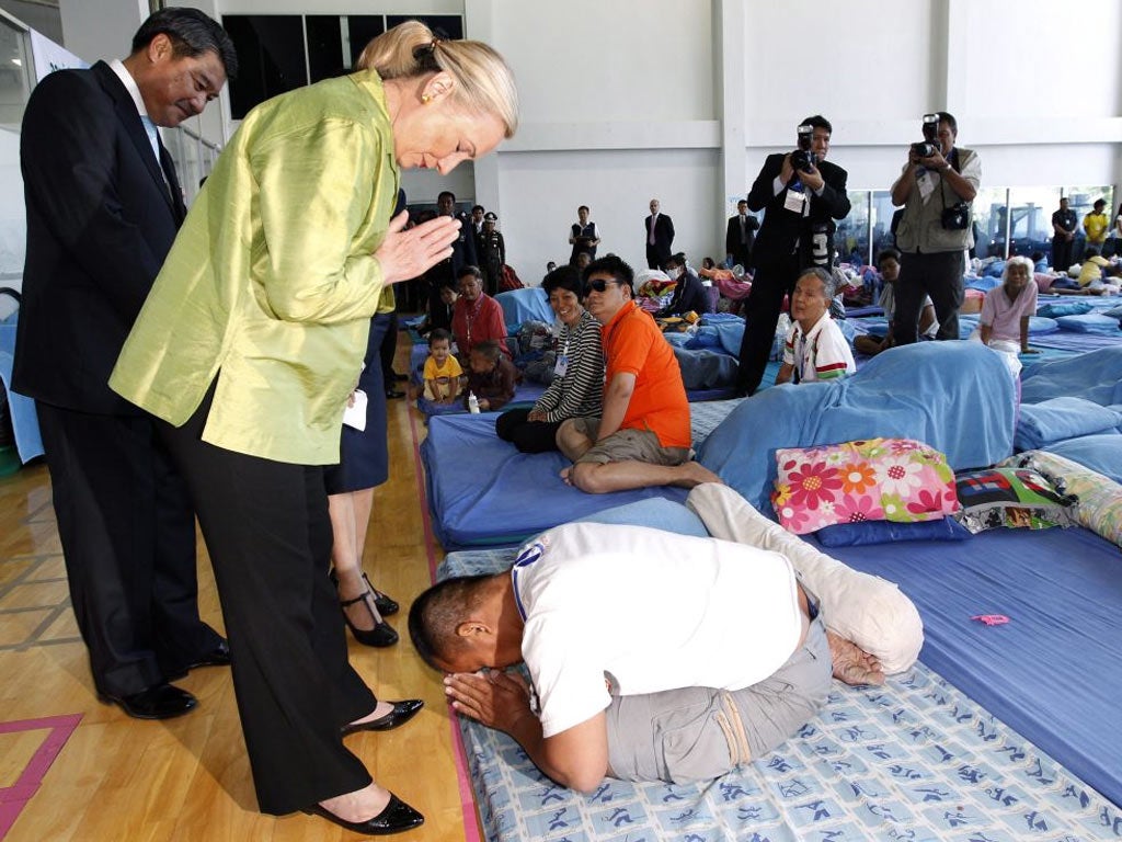 US Secretary of State Hillary Rodham Clinton is shown respect, and returns it, to a Thai flood victim during her visit