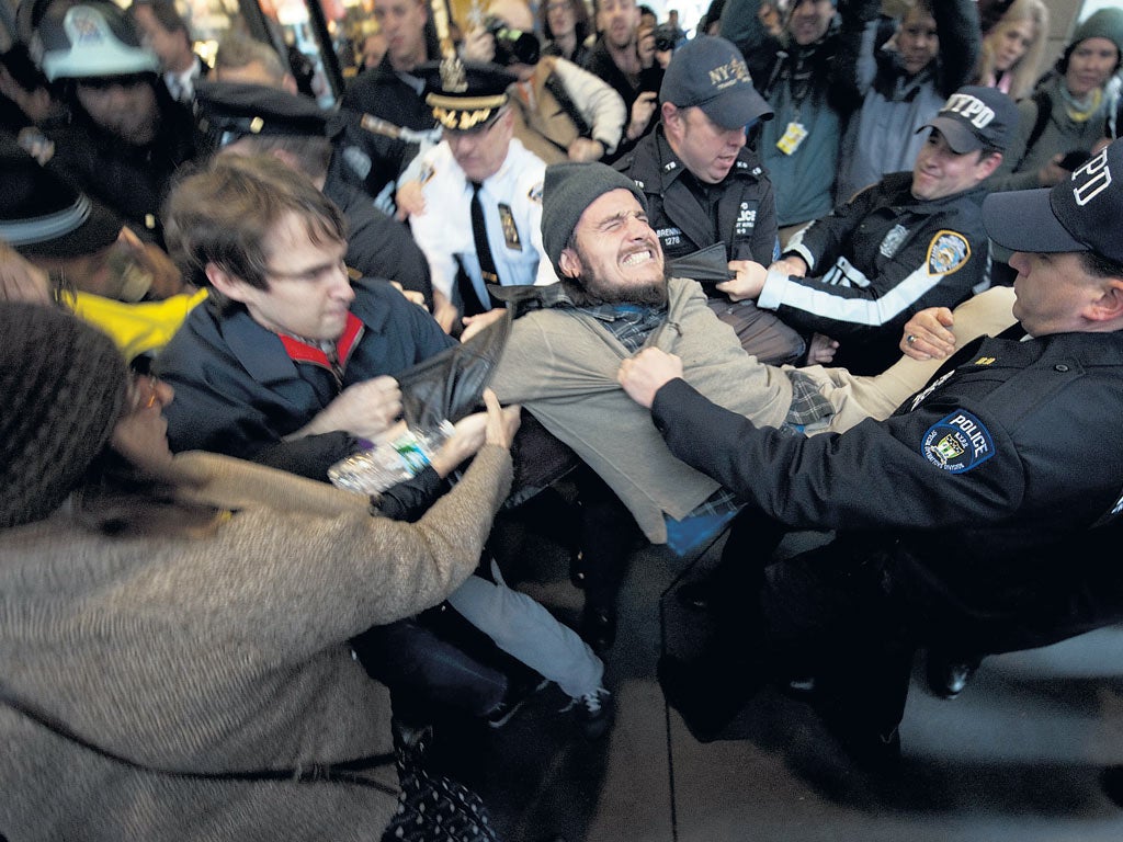 A protester is removed by police as the activists converged on Wall Street yesterday