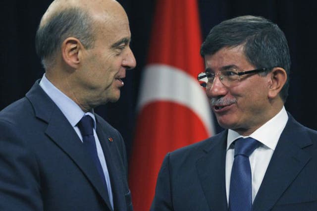 French Foreign Minister Alain Juppe, left, and his Turkish counterpart Ahmet Davutoglu shake hands after the news conference in Ankara