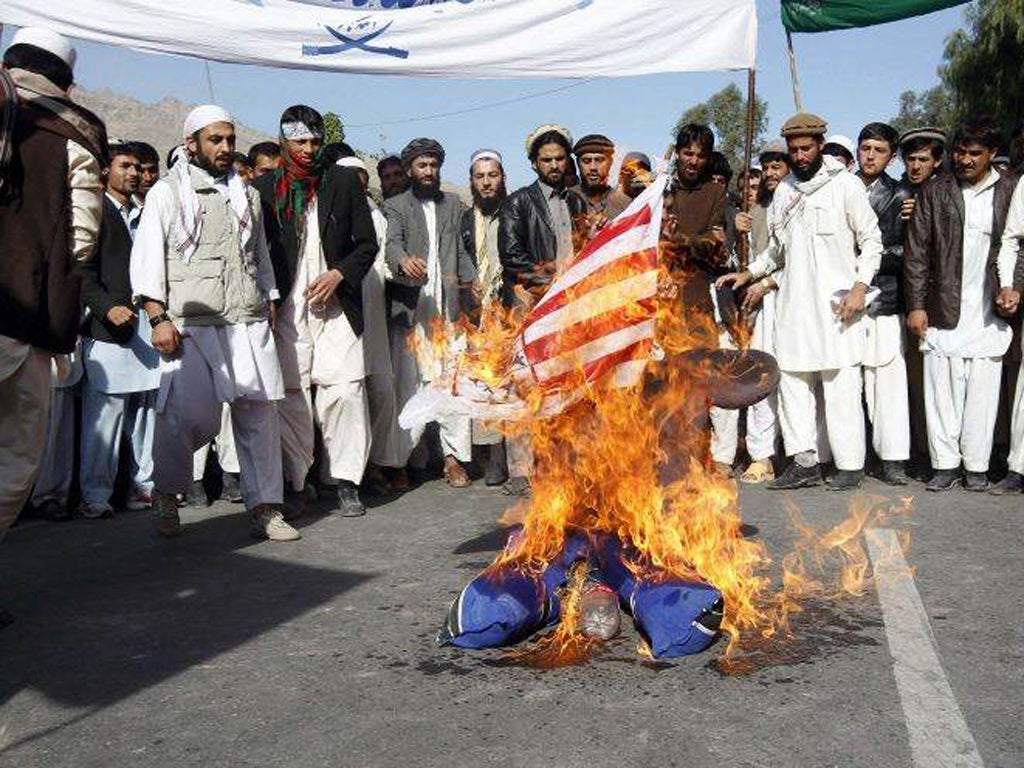 Protesters burn an US flag during a demonstration in Jalalabad