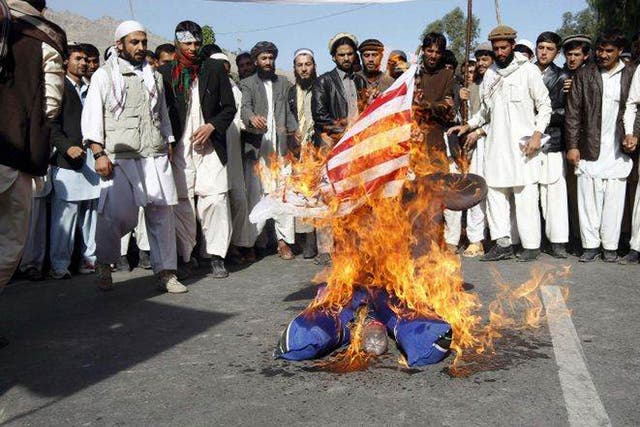 Protesters burn an US flag during a demonstration in Jalalabad 