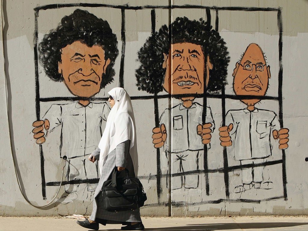 Graffiti in Tripoli depicting Muammar Gaddafi, centre, his son Saif
al-Islam, right, and former spy chief Al-Senussi