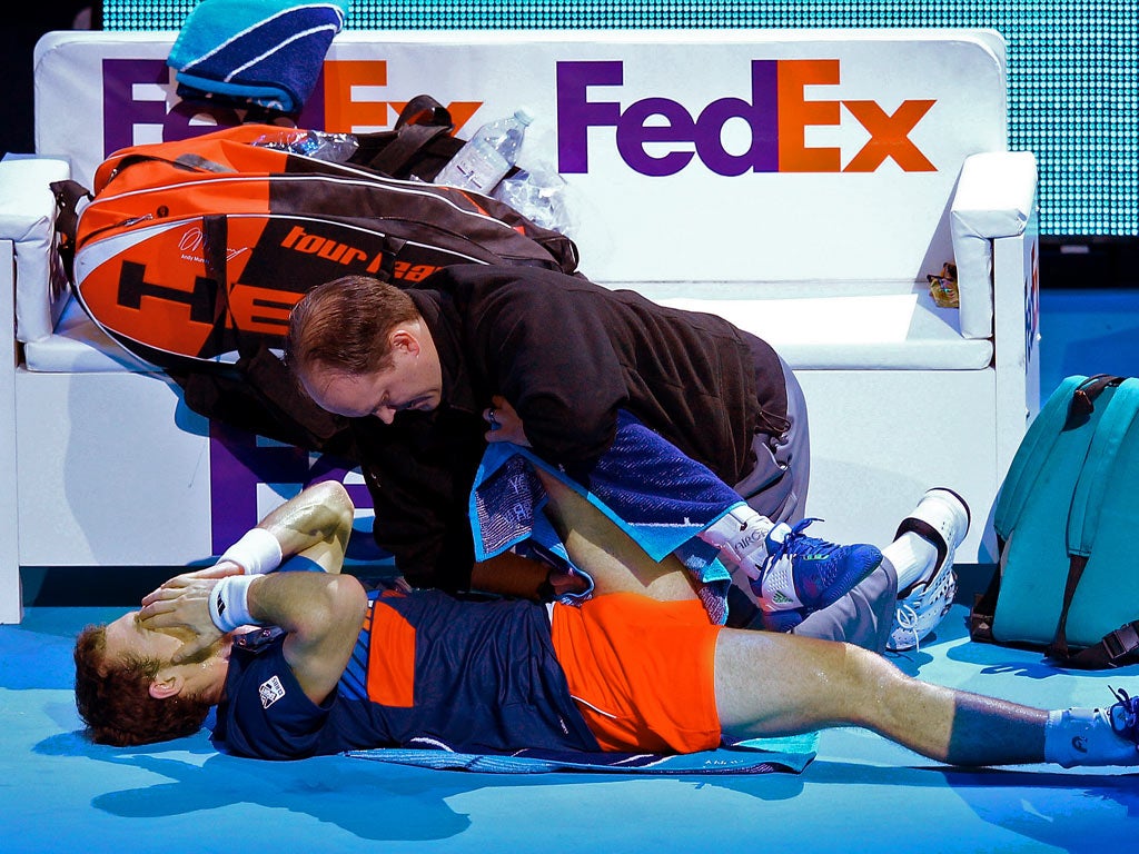 Andy Murray receives medical help during his straight-sets defeat at the O2 yesterday