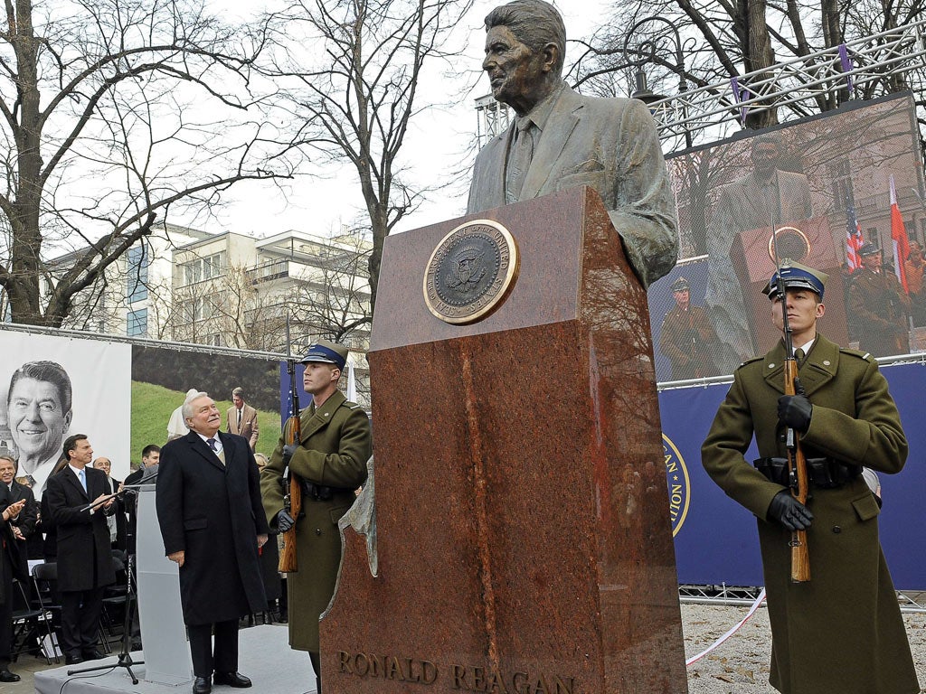 Former Polish President and anti-communist leader Lech Walesa looks up at a statue to former US president Ronald Reagan