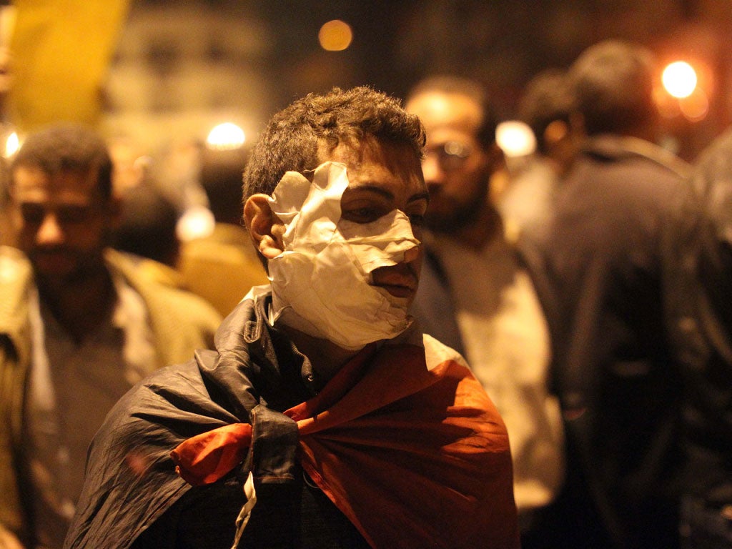 An injured Egyptian protester walks in Tahrir square in Cairo 