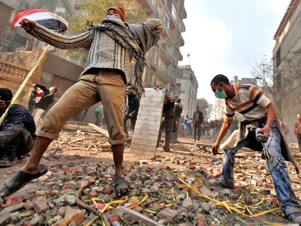 Protesters throw stones at the army near Tahrir Square in Cairo yesterday
