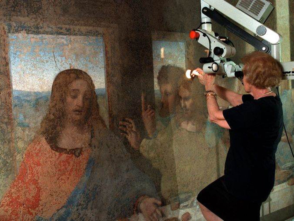 With the help of a powerful microscope, a restorer frees the mural from successive coats of painting and varnish