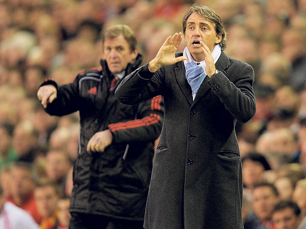 Liverpool manager Kenny Dalglish keeps an eye on his Manchester City opposite number Roberto Mancini during the Premier League encounter at Anfield in April
