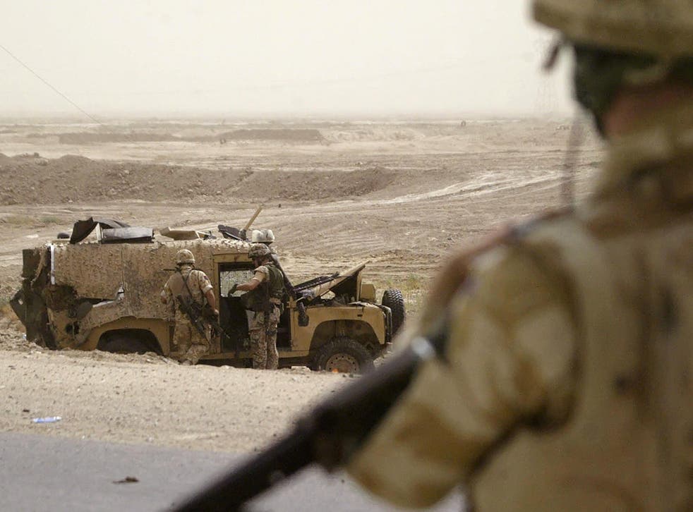 A British soldier guards a Snatch Land Rover after an attack in Iraq