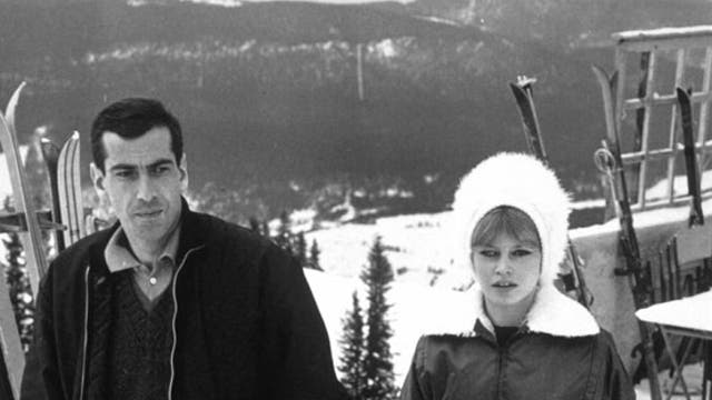 Actress Brigitte Bardot wraps up warm to take a stroll on the slopes with the director Roger Vadim in 1961
