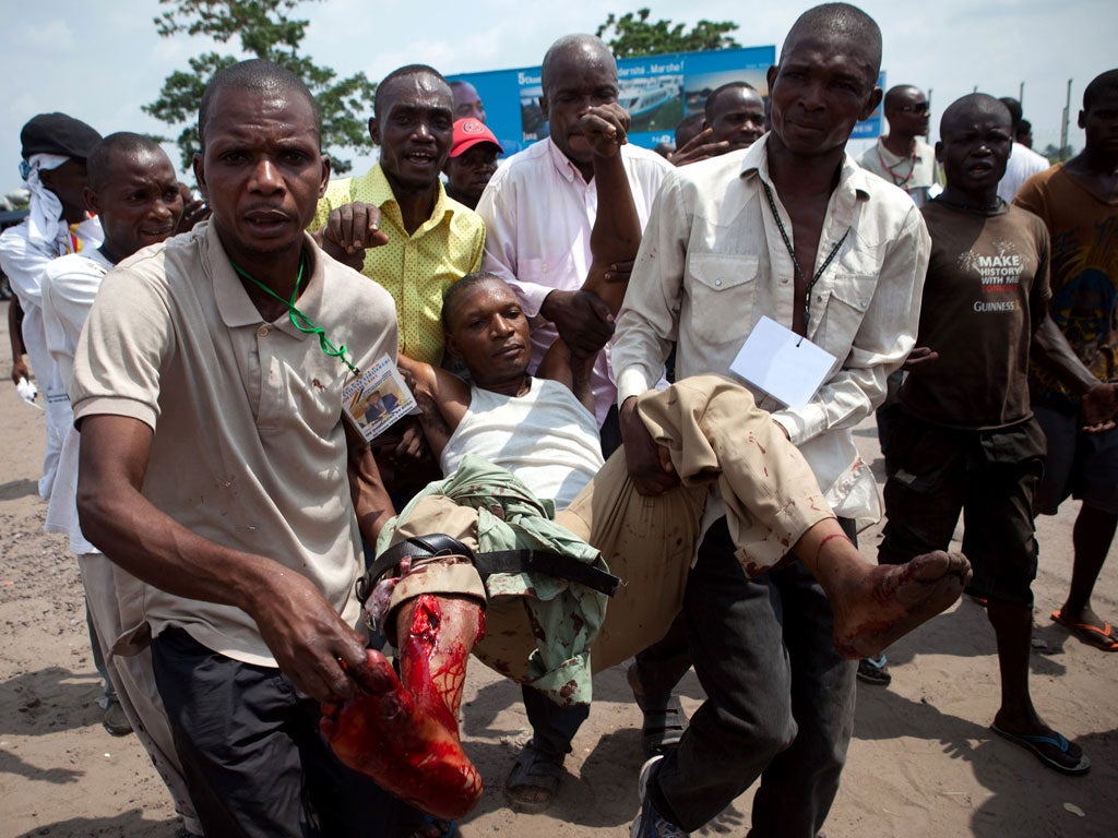 UDPS supporters carry a man after he was shot in the leg by Congolese soldiers in Kinshasa