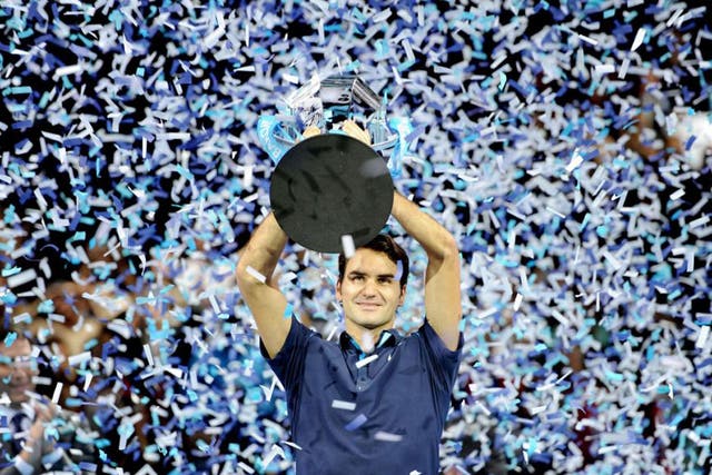 Roger Federer is showered in ticker-tape after receiving the World Tour Finals trophy 
