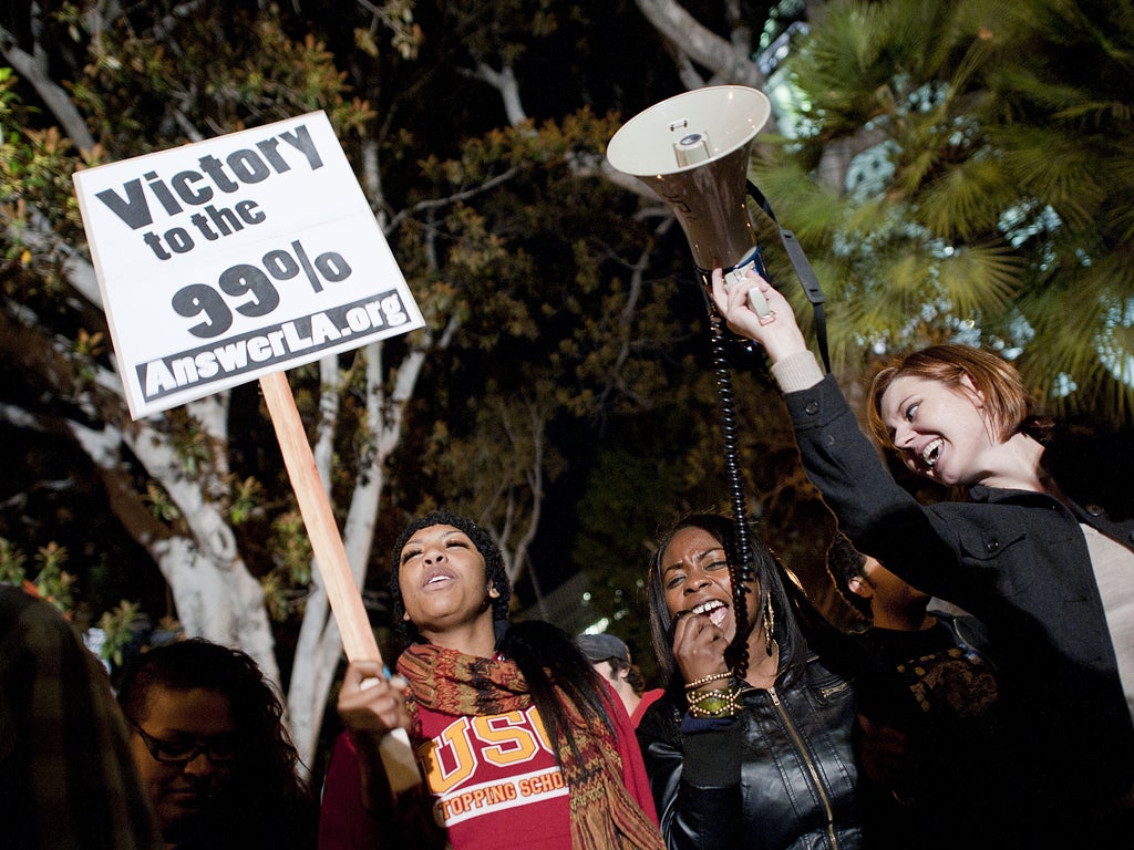 Protesters wave placards outside Los Angeles City Hall