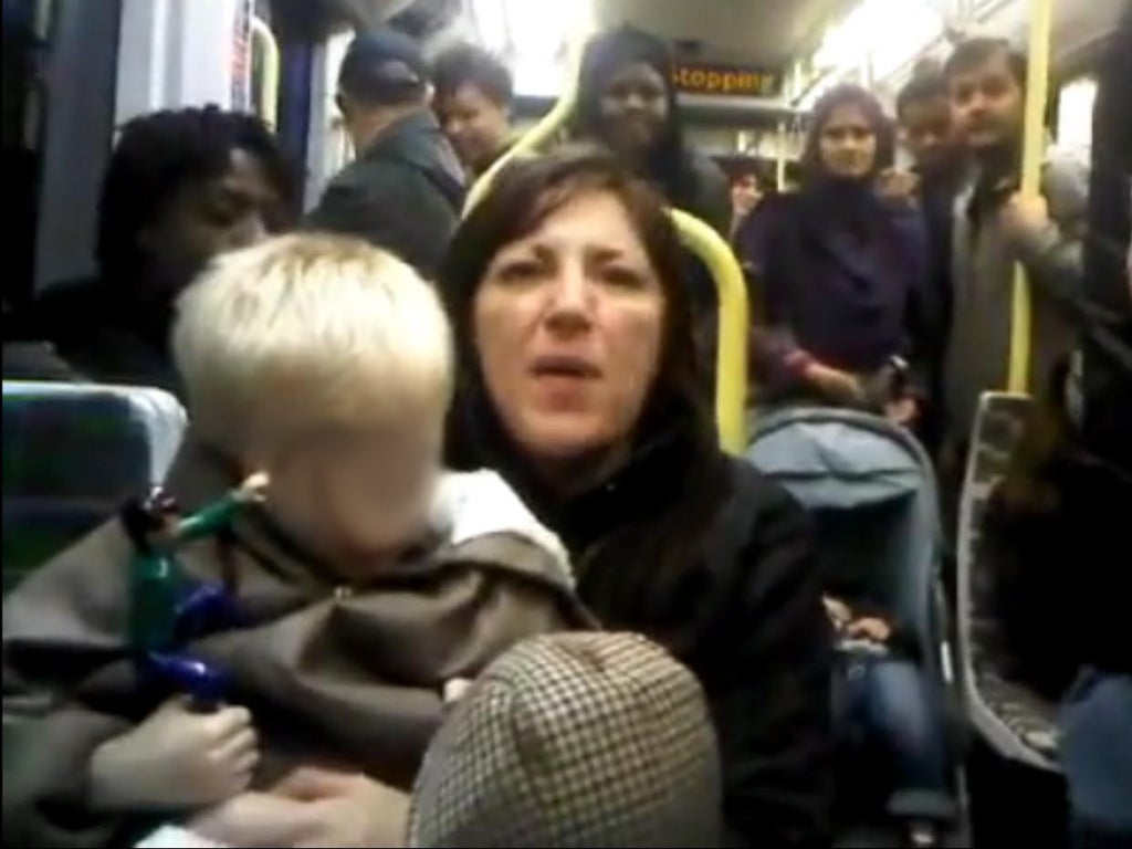 The video shows a woman with a young child on her lap telling another passenger 'you ain't British, you're black'