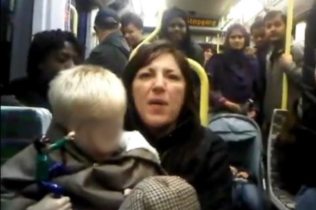 The video shows a woman with a young child on her lap telling another passenger 'you ain't British, you're black'