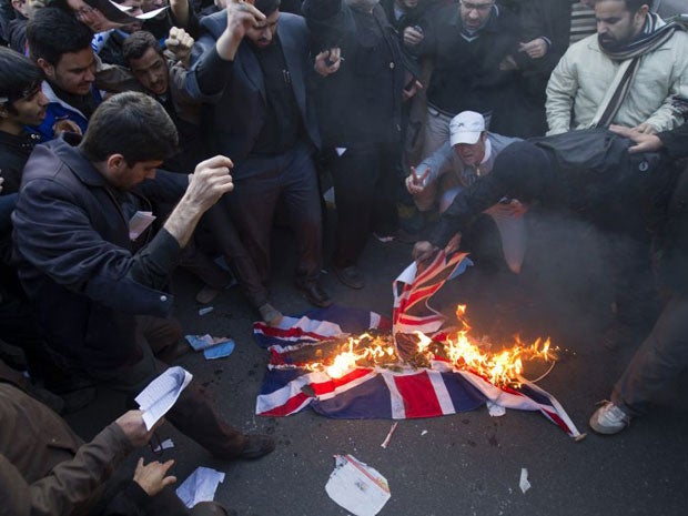 Protesters burn a British flag taken down from the British embassy in Tehran