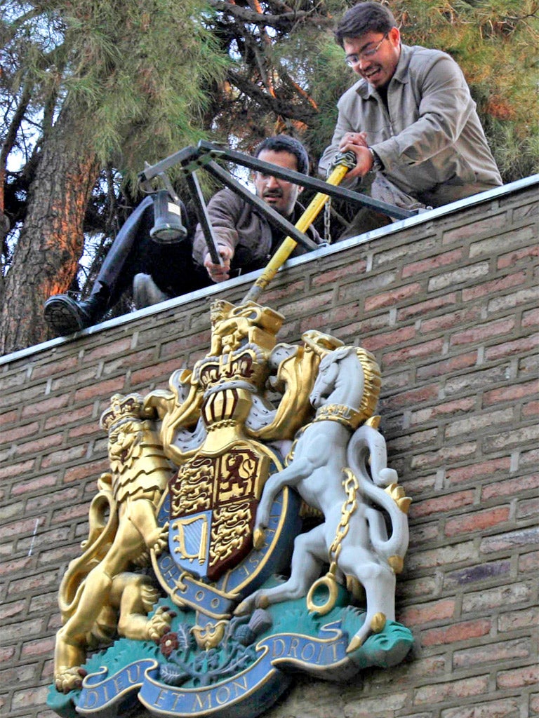 Protesters tear down the royal emblem