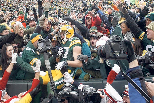 Jordy Nelson is engulfed after doing the traditional
'Lambeau Leap' following a touchdown