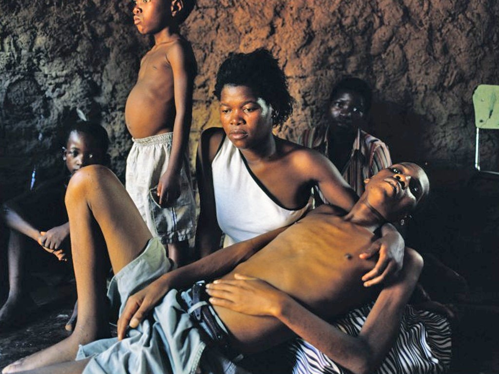 A South African man dying of Aids is held by his wife while their three adopted children - who are also infected - look on