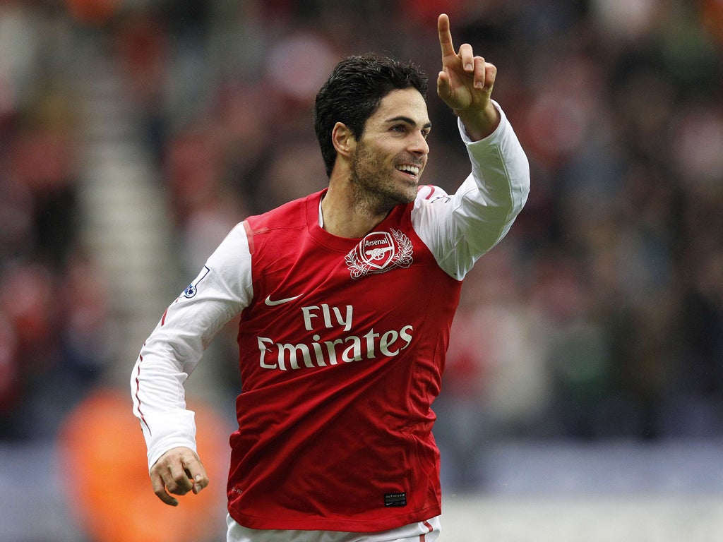 Arsenal's Mikel Arteta celebrates the opening goal yesterday after his tame 25-yard shot slips through the hands of Ali Al Habsi into the net