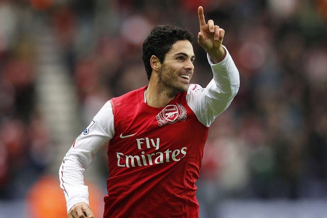 Arsenal's Mikel Arteta celebrates the opening goal yesterday after his tame 25-yard shot slips through the hands of Ali Al Habsi into the net