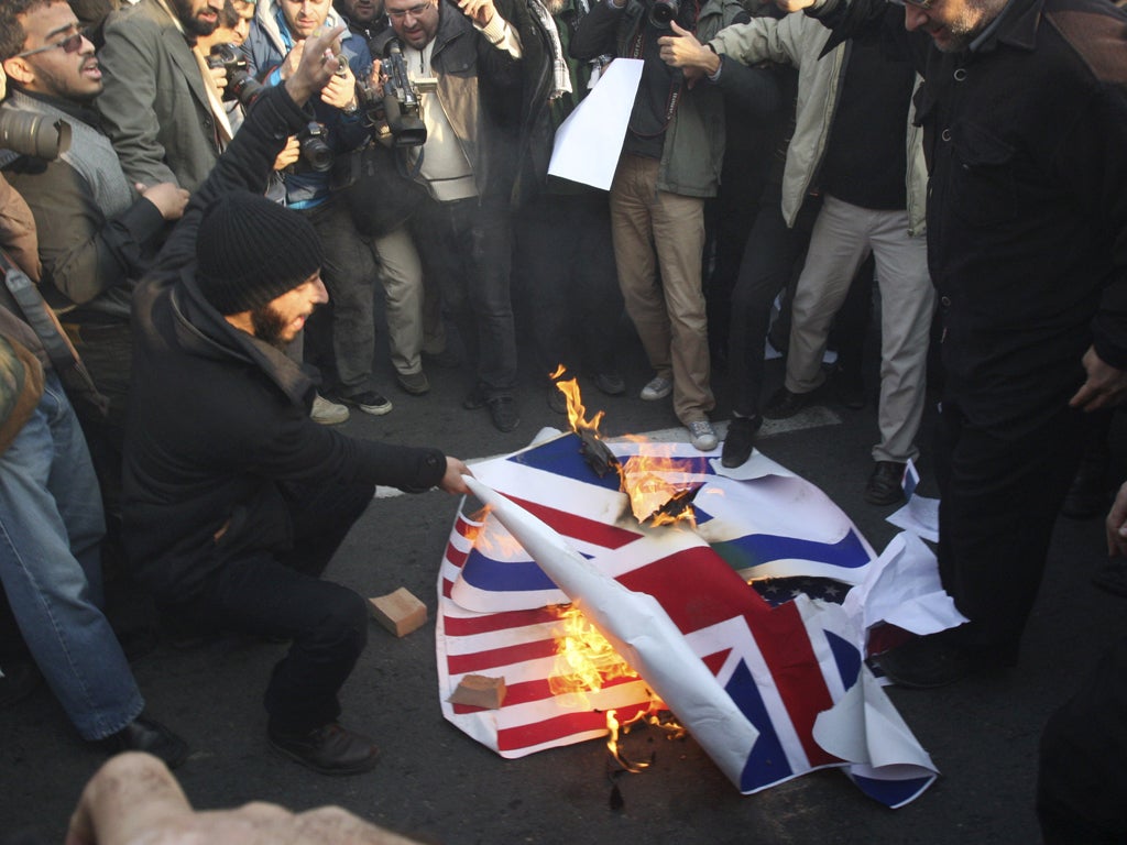 Iranian protesters setting fire to the flags of Britain, Israel and the US on Tuesday