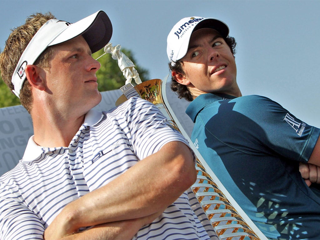 Luke Donald and Rory McIlroy pose next to the Race to Dubai trophy