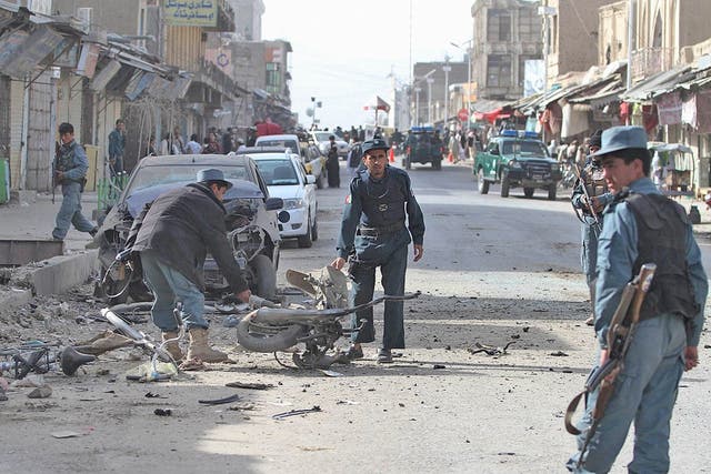 Afghan policemen inspect the scene