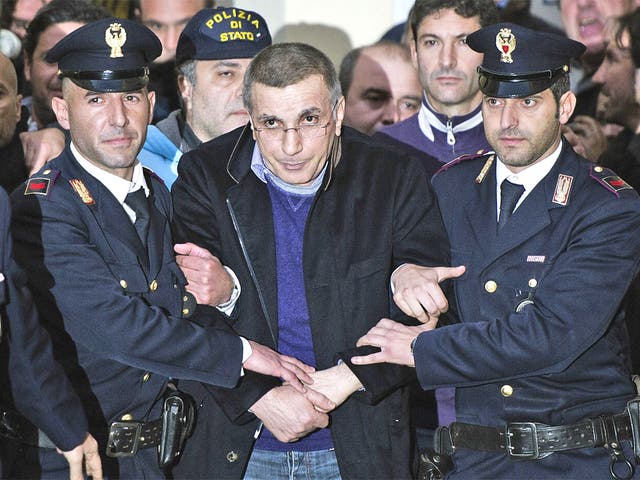 Policemen lead Michele Zagaria away after he was dug out of a bunker built under his home near Naples