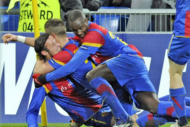 Basle striker Marco Streller is mobbed after putting the Swiss 1-0 up last night