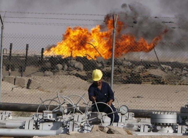 An Iraqi worker operates valves at the Rumaila oil refinery near Basra