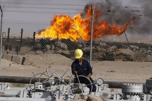 An Iraqi worker operates valves at the Rumaila oil refinery near Basra