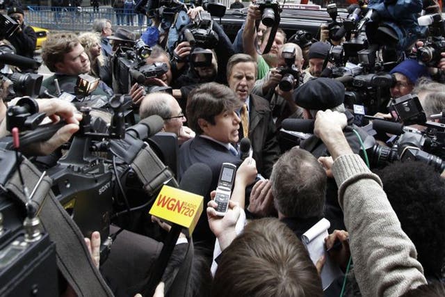 Rod Blagojevich, centre, fights his way through the media scrum as he leaves the federal court in Chicago