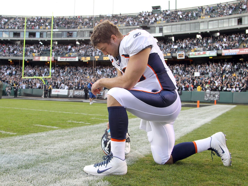 Tim Tebow gives thanks in his trademark pose which has become known as 'Tebowing' and has swept across America via YouTube