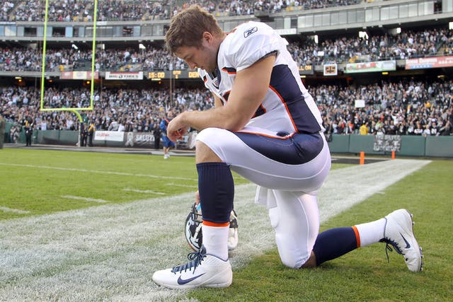 Tim Tebow gives thanks in his trademark pose which has become known as 'Tebowing' and has swept across America via YouTube