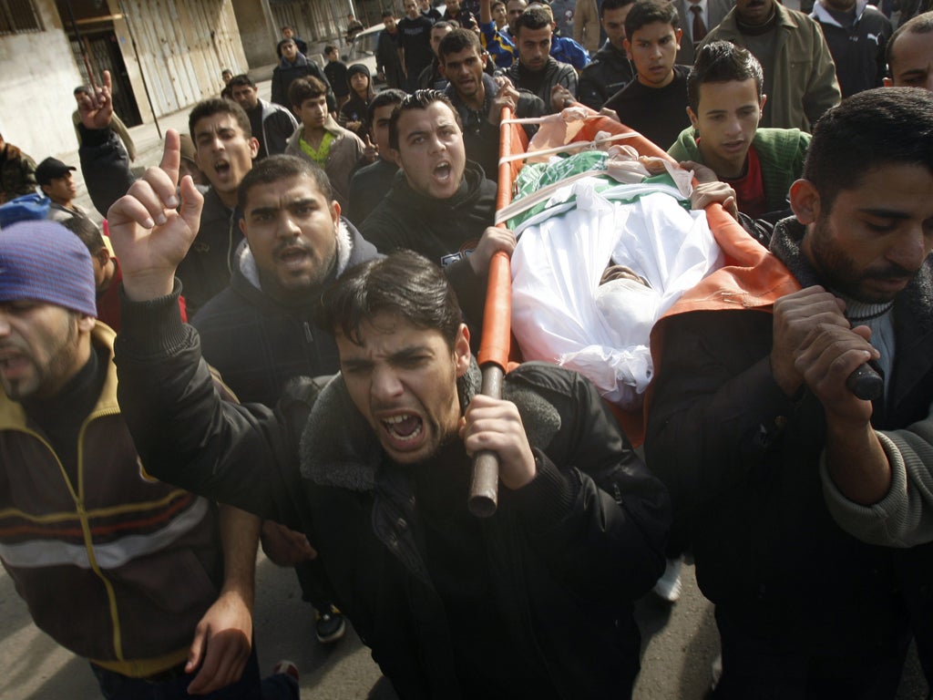 The body of a Palestinian killed in his home by an Israeli air strike is carried through Gaza City