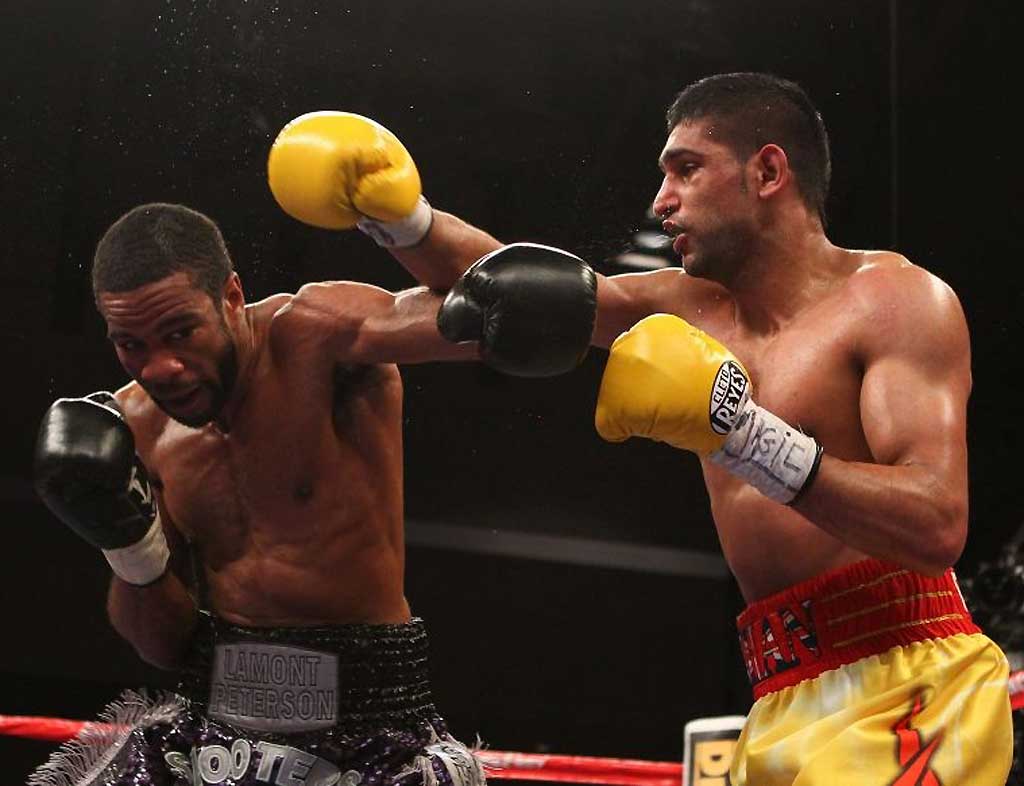 Amir Khan and Lamont Peterson exchange punches during their WBA Super Lightweight and IBF Junior Welterweight title fight in Washington