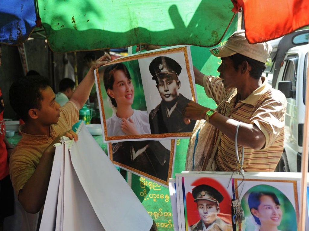 A vendor (R) sells posters of Myanmar's independence hero General Aung San and his daughter democracy icon Aung San Suu Kyi