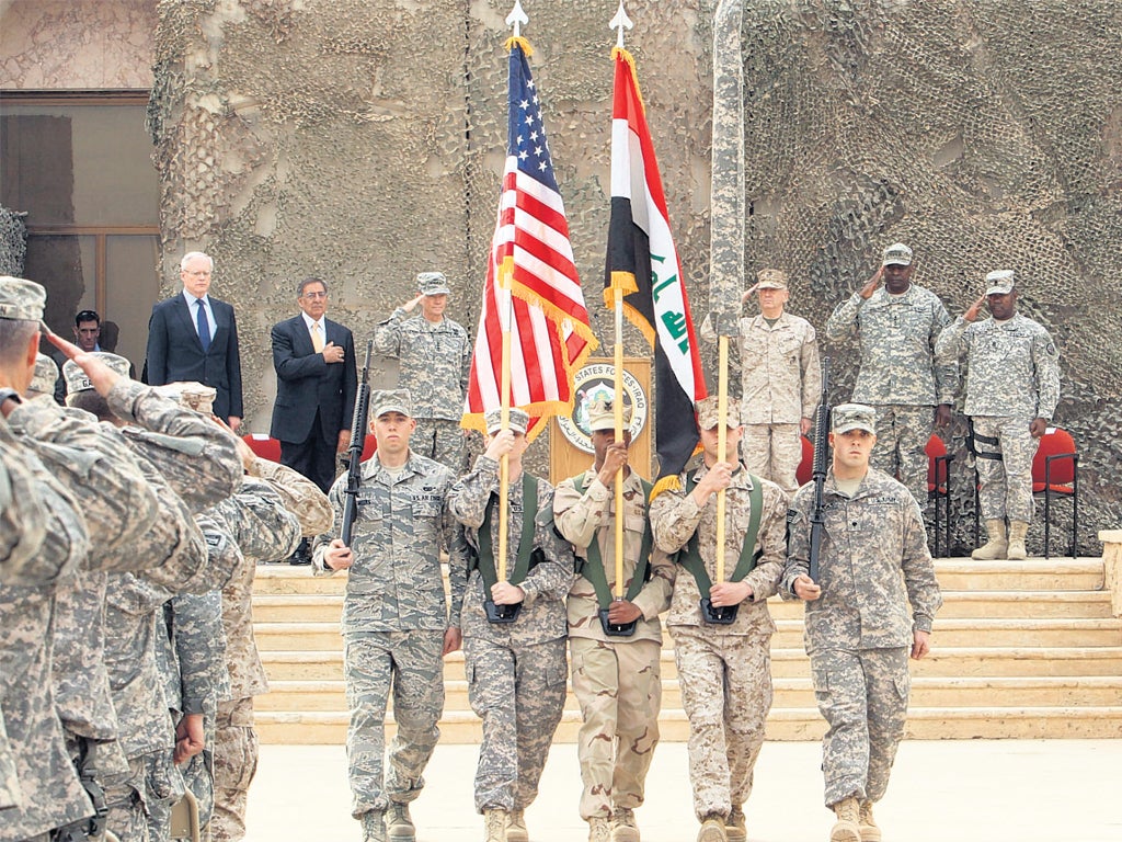 US officials including Defence Secretary Leon Panetta watch the flag-lowering ceremony at a base near Baghdad