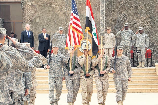 <p>US officials including Defence Secretary Leon Panetta watch the flag-lowering ceremony at a base near Baghdad </p>