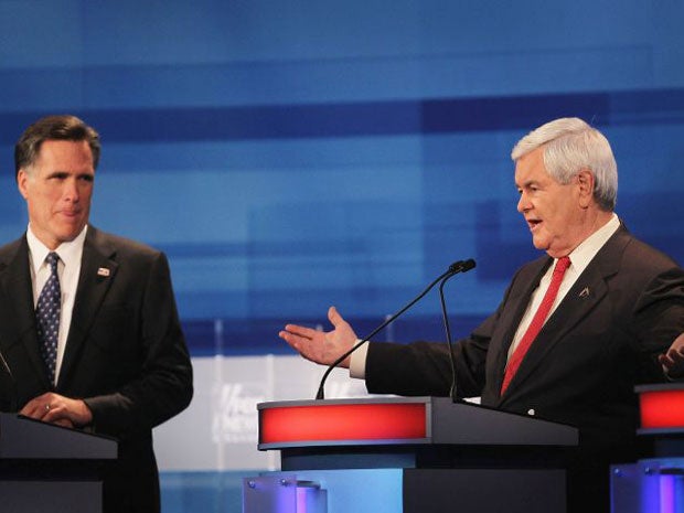 Mitt Romney (left) listens as Newt Gingrich answers a question during last night's debate
