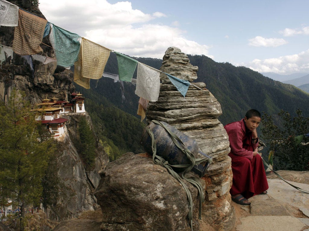 <p>Save a prayer: A teenage monk rests during a walk from the Tiger’s Nest monastery</p>