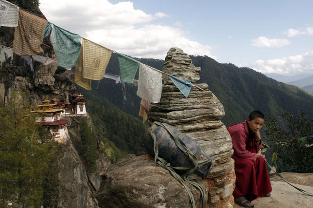 <p>Save a prayer: A teenage monk rests during a walk from the Tiger’s Nest monastery</p>