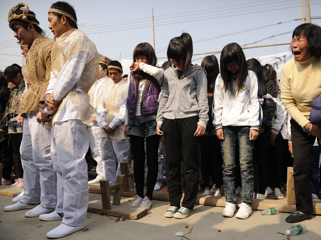 <p>Relatives and friends of Xue Jinbo, who died in police custody, attend his funeral in Wukan yesterday</p>