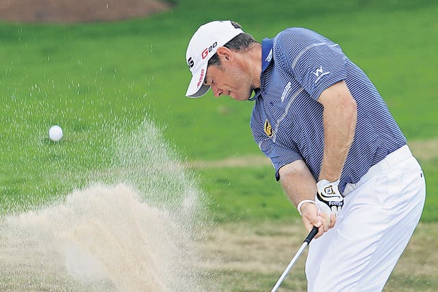 <p>Trap negotiated: Lee Westwood splashes out of a bunker during his third-round 73 in Bangkok yesterday</p>