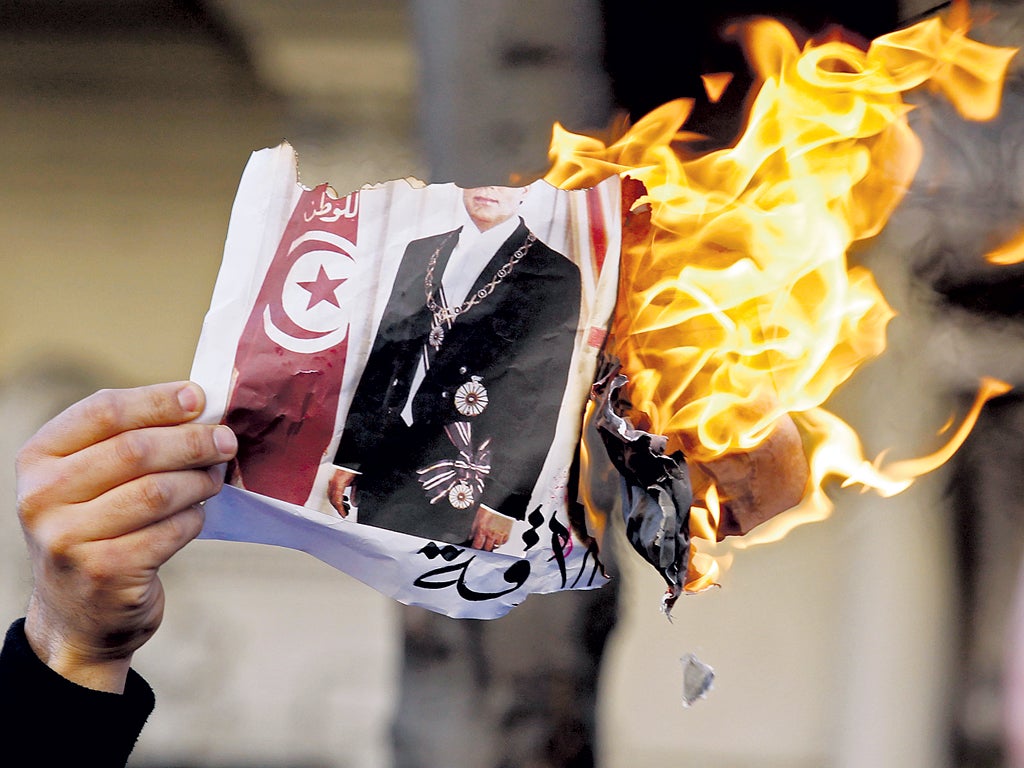 A Tunisian burns an image of his country’s former ruler, Zine al-Abidine Ben Ali